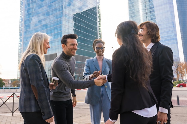 A group of multiethnic business people in a business park introducing themselves and shaking hands