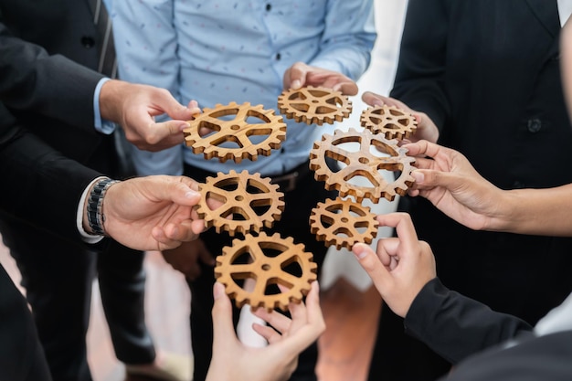 Group of multiracial business people joining gear wheels together meticulous