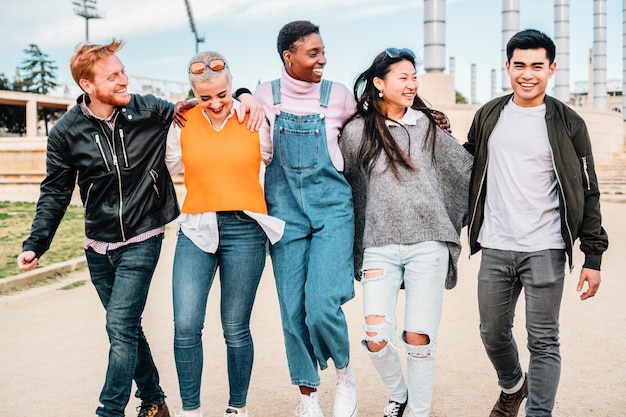 Group of multiracial friends meeting walking together and hugging