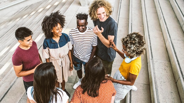 Group of multiracial young people having fun together on city street