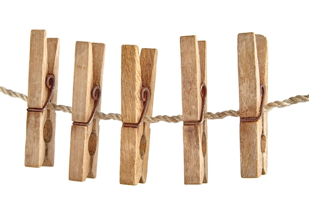 Group of old shabby wooden clothespins hanging on a clothesline isolated on white background