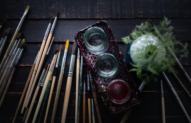 Group of old used paintbrushes on dark wooden backgroundFlat lay