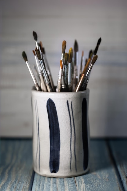 Group of old used paintbrushes in jarsoft focus and shallow depth of field composition