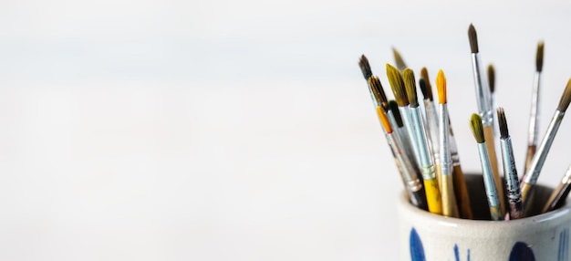 Group of old used paintbrushes in jarsoft focus and shallow depth of field composition