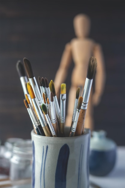 Group of old used paintbrushes in jarsoft focus and shallow depth of field composition