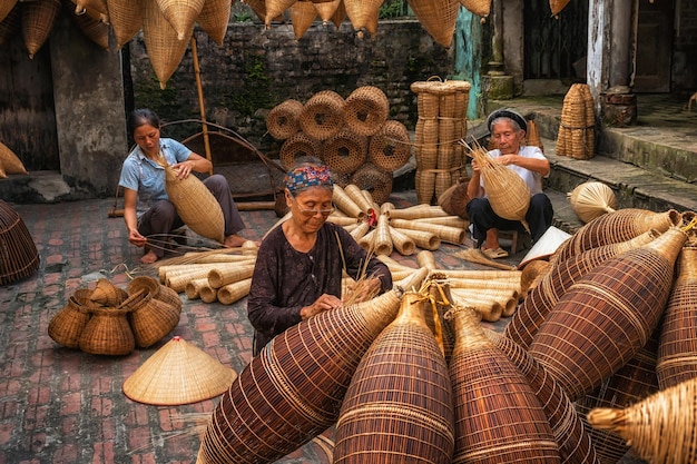 Group of Old Vietnamese female craftsman making the traditional bamboo fish trap