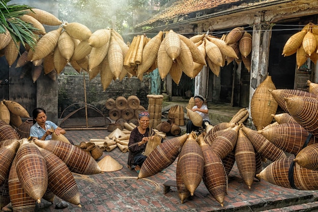 Group of Old Vietnamese female craftsman making the traditional bamboo fish trap