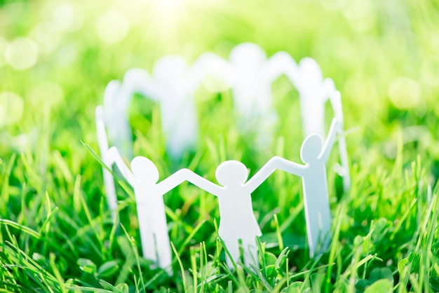 Group of paper people holding hands together Concept of social help in group Team concept