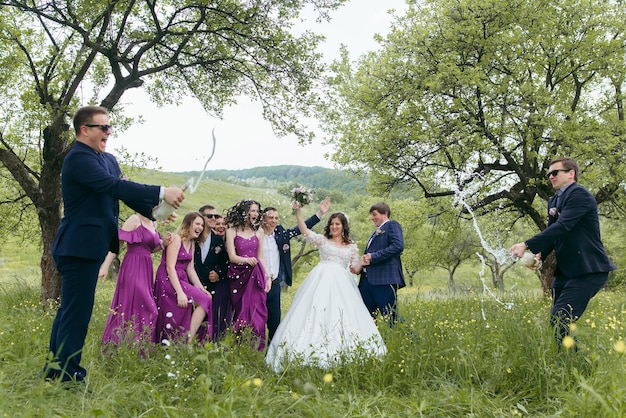 A group of people are celebrating a wedding in a field