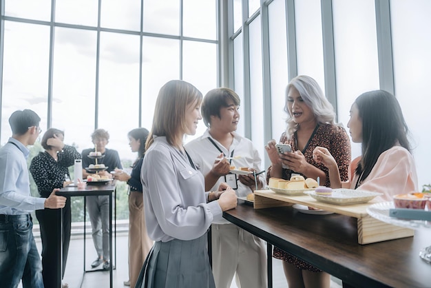 a group of people are gathered around a table with food and drinks