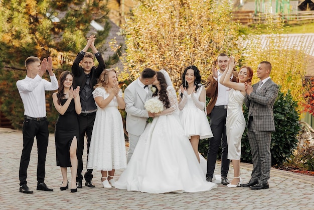 A group of people are posing for a picture with a bride and groom in the center