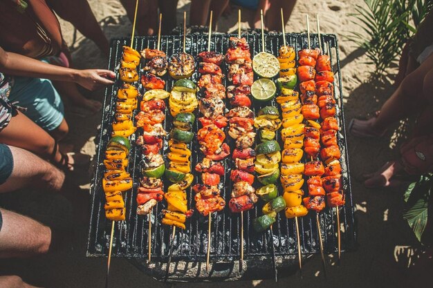 Photo a group of people are standing around a grill with food on it