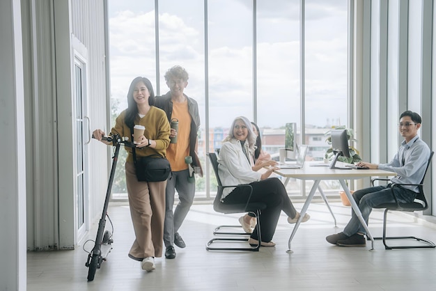 a group of people are standing in a room with a large window behind them