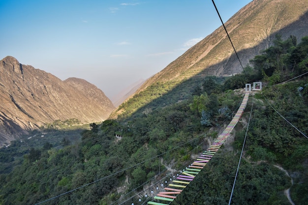 Group of people crossing a TIBETAN BRIDGE tourist attraction in San Mateo de Otao Peru