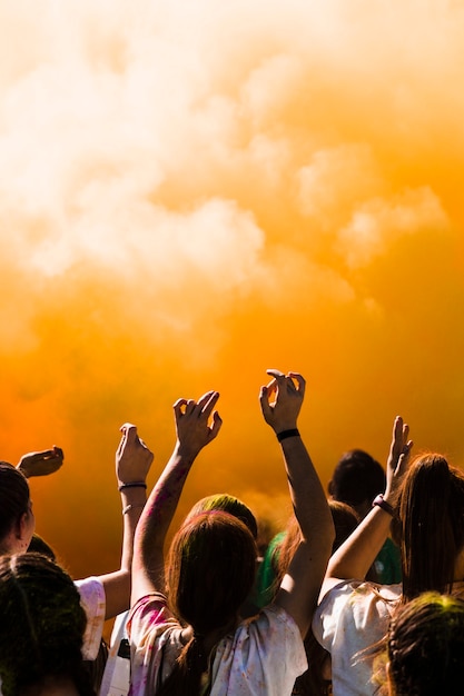 Group of people dancing in front of holi powder explosion