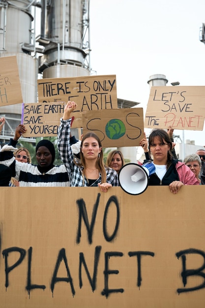 Photo group of people of different ages and nationalities with arms raised in protest against pollution