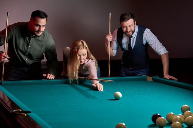 Group of people or friends playing fun billiards, snooker or pool together, enjoy leisure time. fun, billiards, leisure, rest concept