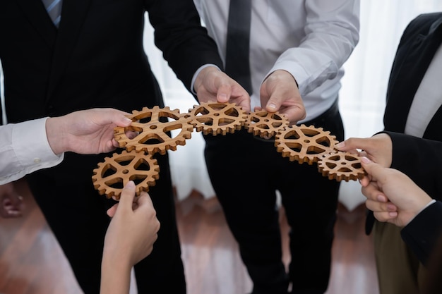 Group of people making chain of gears into collective form for harmony symbol