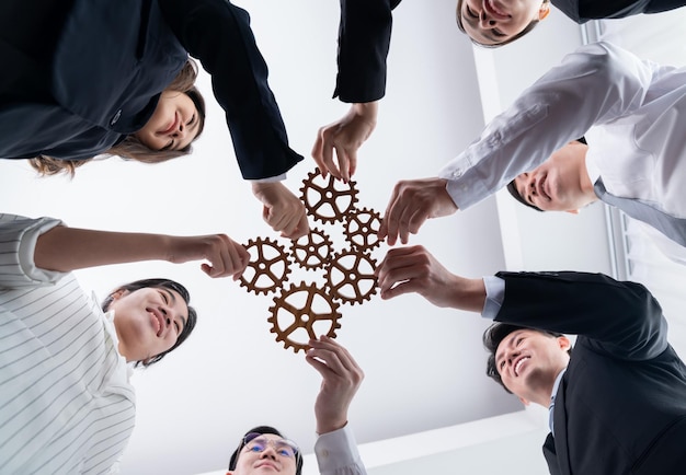 Group of people making chain of gears into collective form for harmony symbol