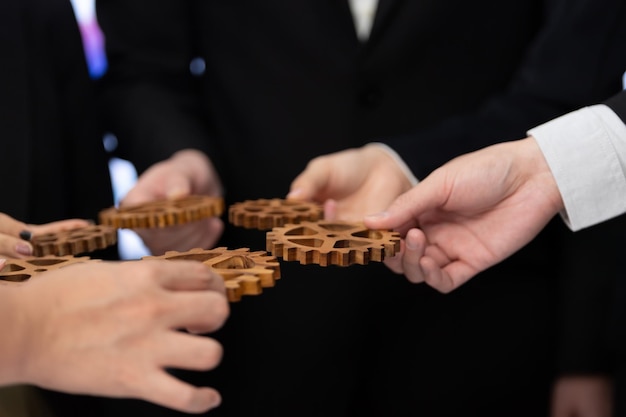 Group of people making chain of gears into collective form for harmony symbol