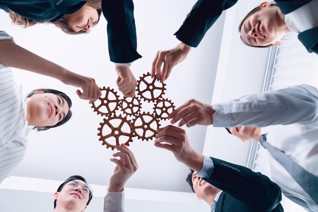 Group of people making chain of gears into collective form for harmony symbol