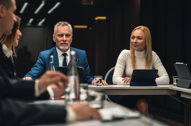 The group of people sitting at the table on business conference