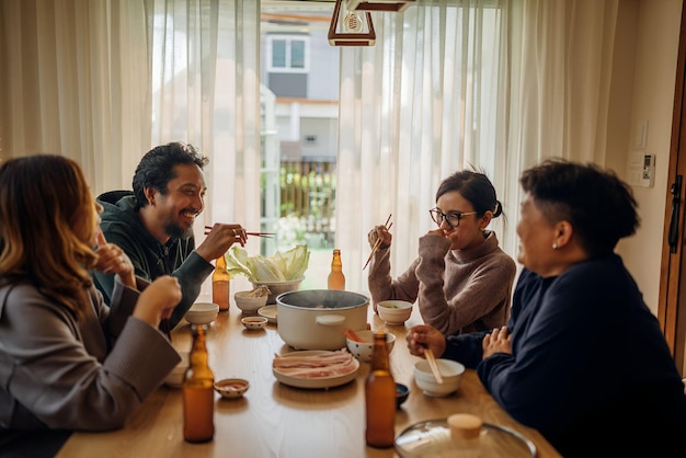 a group of people sitting at a table with food and drinks