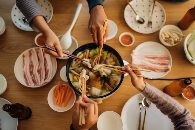 a group of people sitting at a table with food and drinks