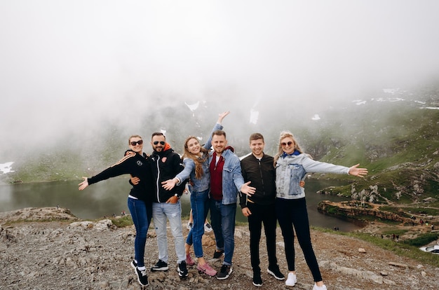 A group of people stand on a mountain top in the fog.