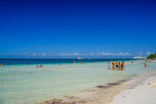 Group of people standin in the water beach on a sunny day in Cancun Yukatan Mexico