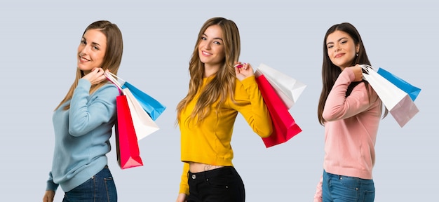 Group of people with colorful clothes holding a lot of shopping bags on colorful background