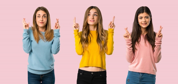 Photo group of people with colorful clothes with fingers crossing and wishing the best