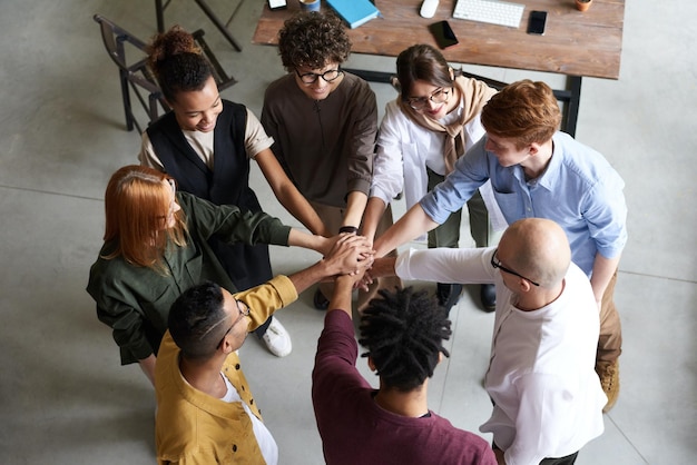 a group of people with hands together one of which is holding a group of people