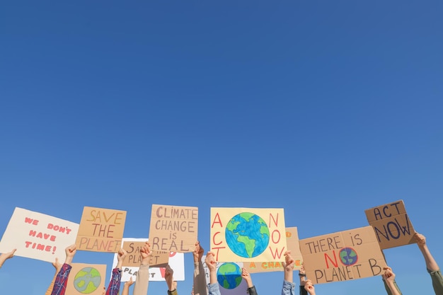 Photo group of people with posters protesting against climate change outdoors closeup