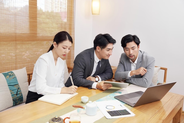 Group of people working out business plan in house tea