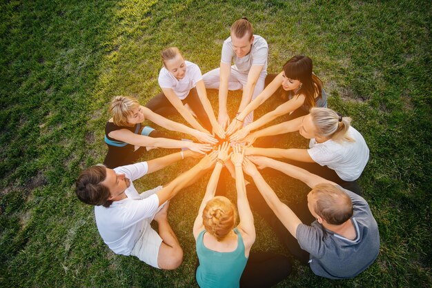 Photo a group of people do yoga in a circle in the open air during sunset. healthy lifestyle, meditation and wellness.