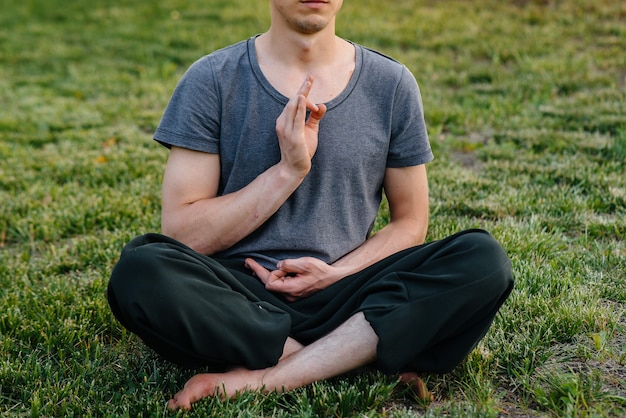 A group of people do yoga in the Park at sunset