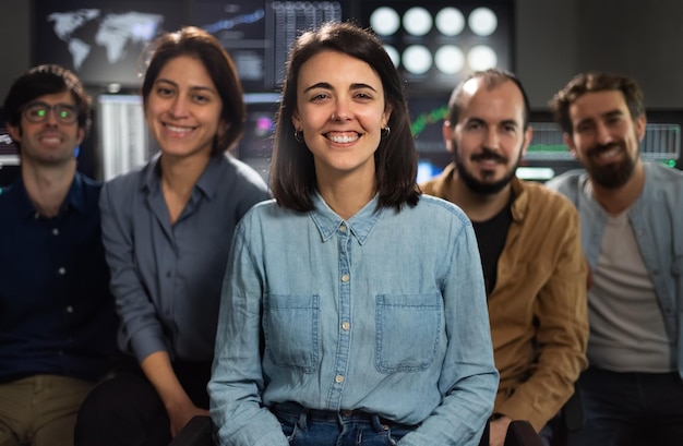 Group photo of stock traders teams in the office looking at camera Focus on woman in the middle