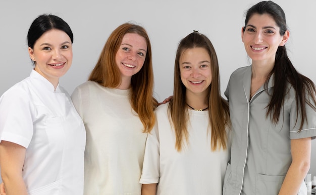 Group portrait of cosmetologists in uniform smiling at camera