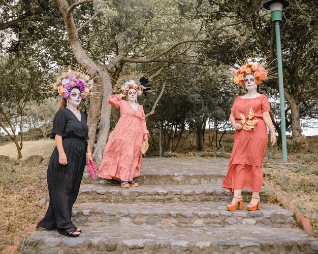 Group portrait of three women with the makeup of the catrinas. Makeup for day of the dead.