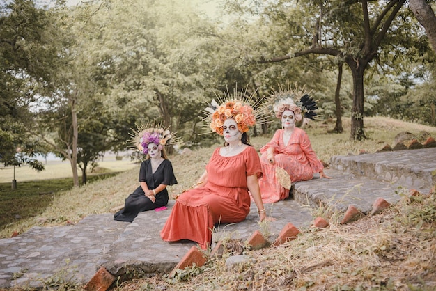 Group portrait of three women with the makeup of the catrinas. Makeup for day of the dead.