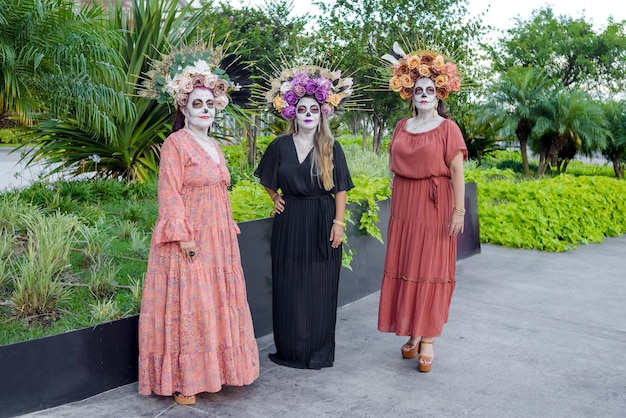 Group portrait of three women with the makeup of the catrinas. Makeup for day of the dead.