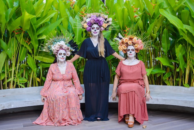 Group portrait of three women with the makeup of the catrinas. Makeup for day of the dead.