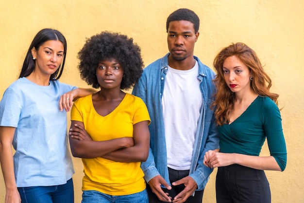 Group portrait of young multi ethnic friends against yellow wall international youth community people concept