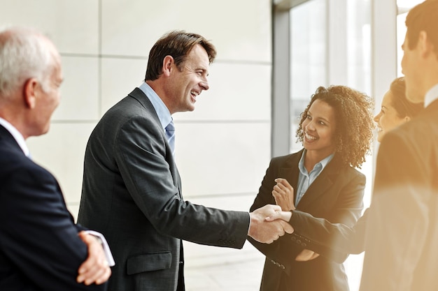 Group professional and negotiation with handshake for agreement with conversation at the office Business people and welcome partner in the lobby for a discussion about contract in the company