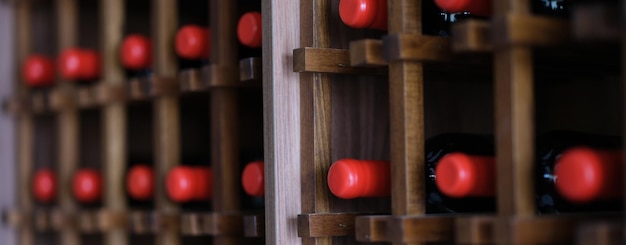 Group of red wine bottles stacked on wooden racks