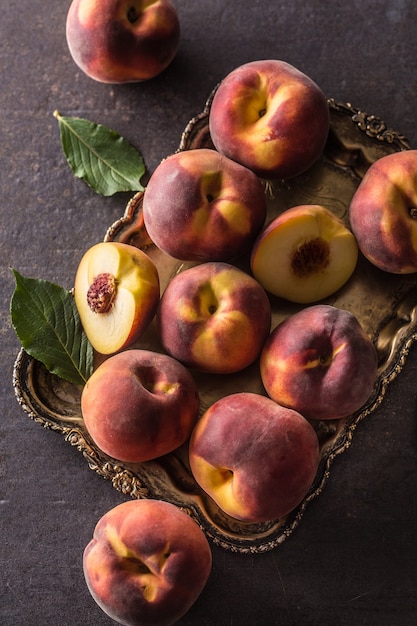 A group a ripe peaches in rustic bowl.