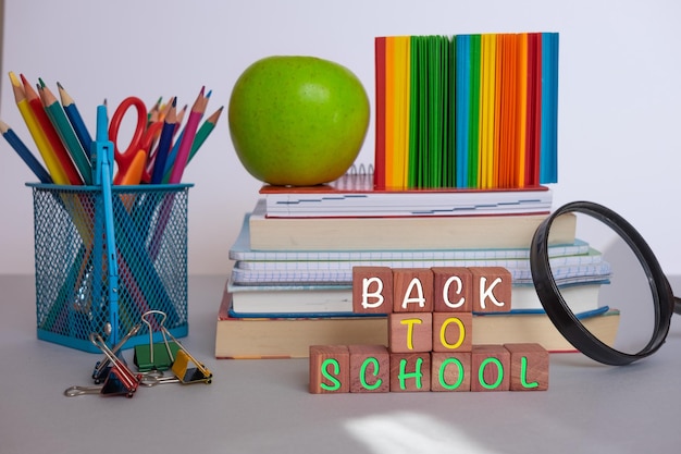 Group of school supplies and books over a desk student accessories teacher's day text back to school concept