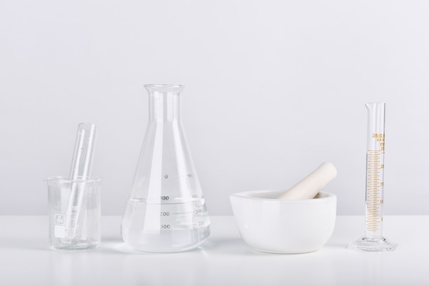 Group of scientific laboratory glassware and mortar with clear liquid solution, Research and development concept.