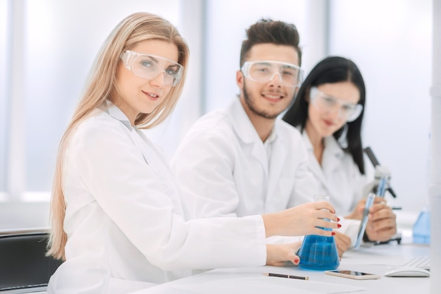 group of scientists discuss the liquid in the flask. science and health